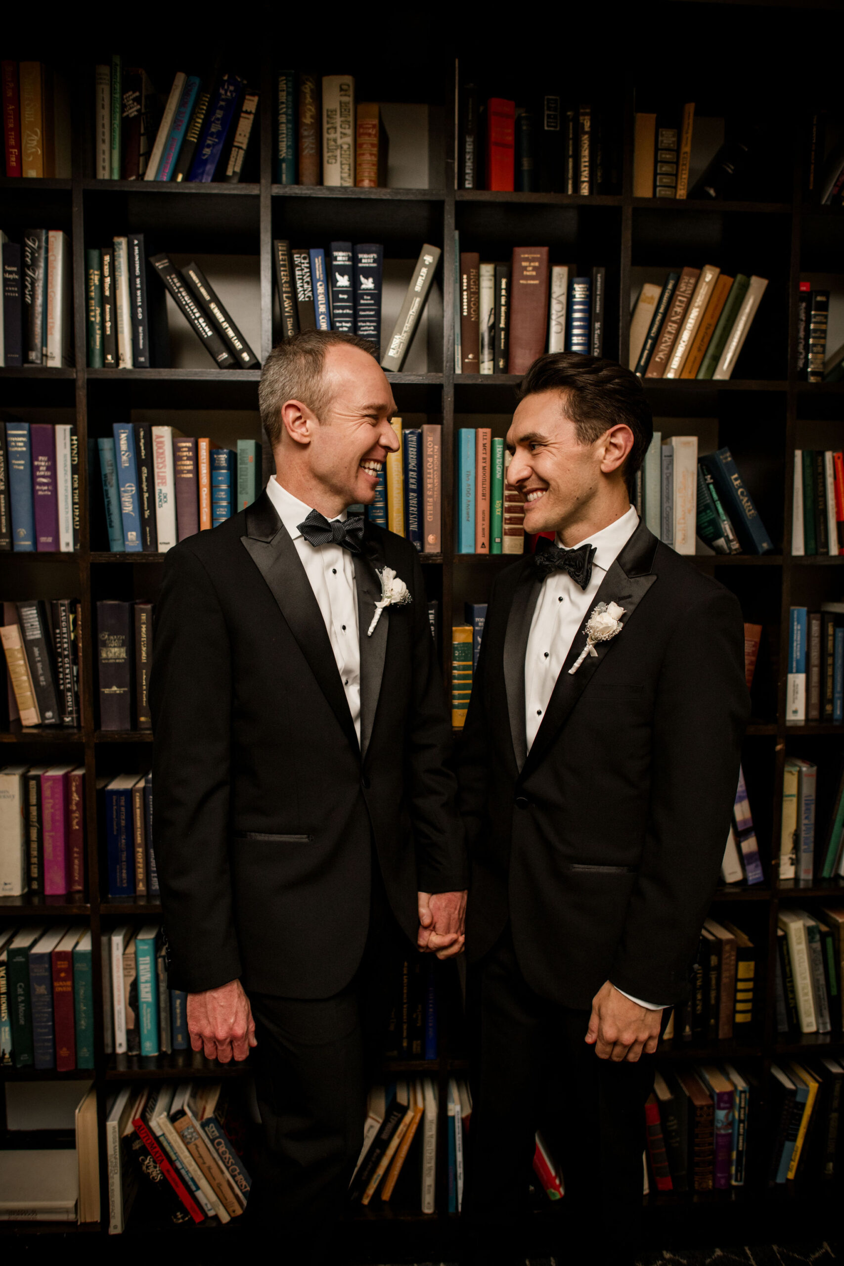 Two Grooms looking at each other in a library in Houston, TX 